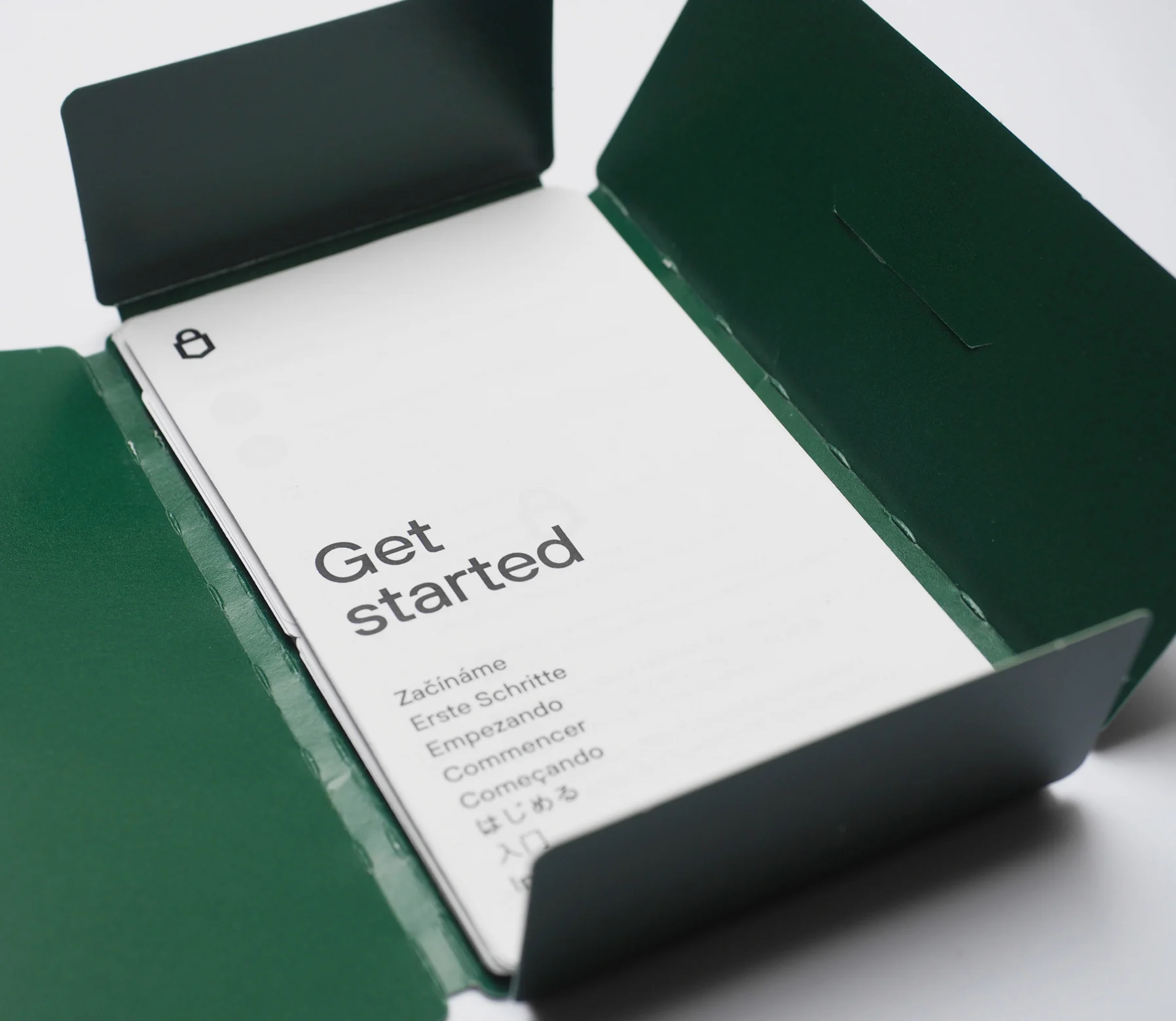 The green wallet opened to the white “Get started” card, the heading repeated in eight languages.